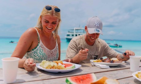 A couple enjoying an all-inclusive lunch on the beach