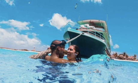 A couple snorkeling in front of the boat at Klein Curaçao